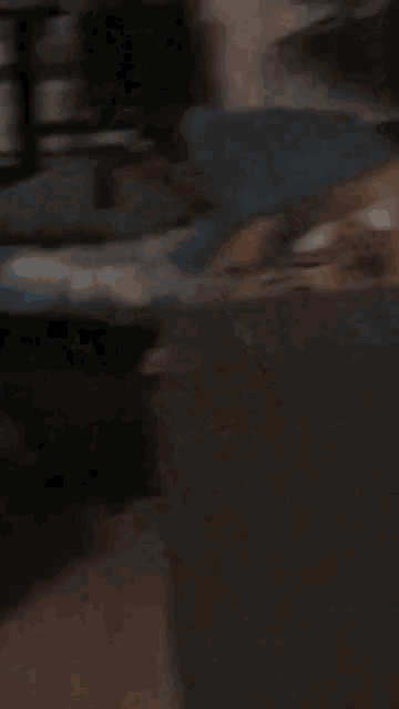 a man with a beard is smoking a cigarette while sitting on a couch in a dark room .