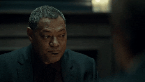 a man in a suit and tie is looking at something