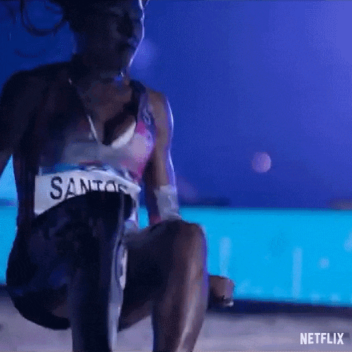 a woman with a prosthetic leg is squatting down in front of a pool in a dark room .