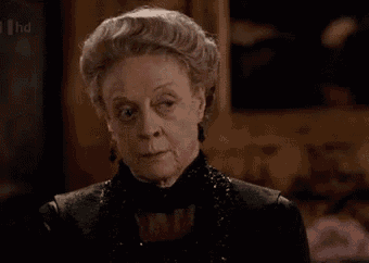 an older woman with gray hair is wearing a black dress and a black top .