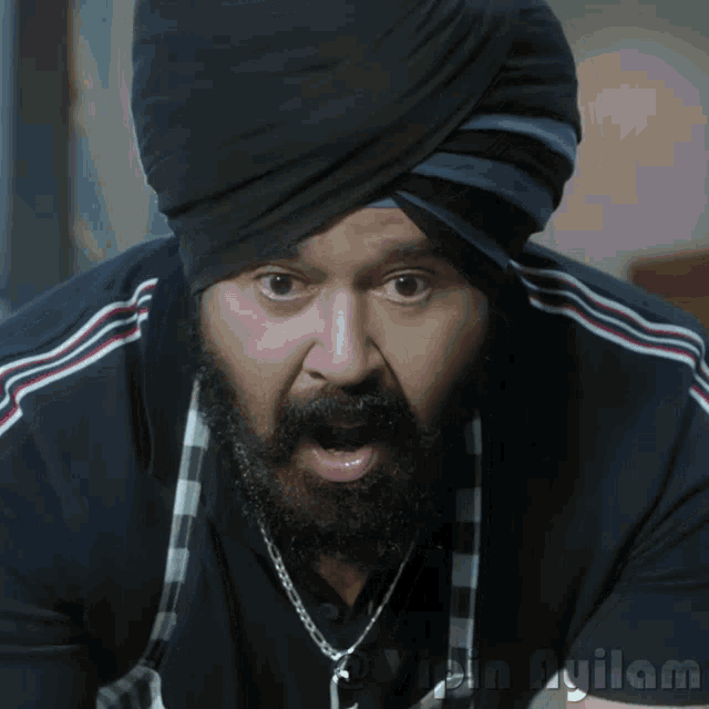 a man with a beard wearing a turban and a necklace with the word fujilam on it