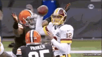 a football player with the number 12 on his jersey is about to throw the ball