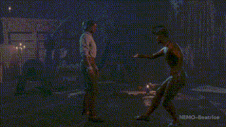 a man in a white shirt is standing in a dark room with nemo beatrice written on the bottom right