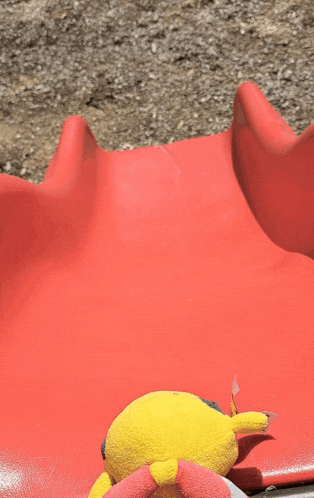 a stuffed animal sits on a red slide