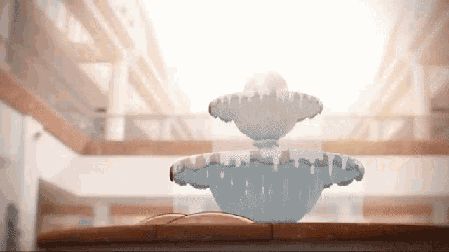 a water fountain is sitting on a wooden table in a room .