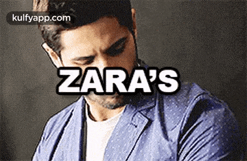 a man in a blue jacket is talking on a cell phone with the word zara 's written above him .