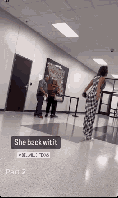 a woman in a bellville texas jumpsuit stands in a hallway