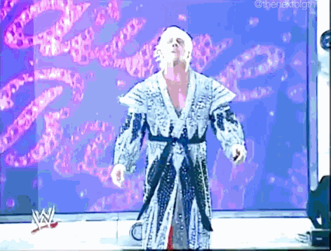 a man in a robe is standing in front of a sign that says w