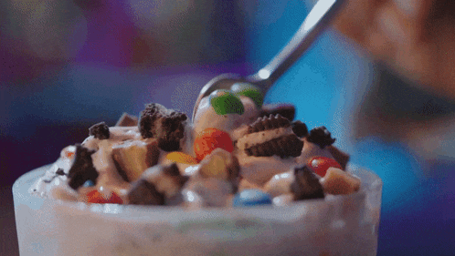 a close up of a bowl of ice cream with m & m 's and oreos
