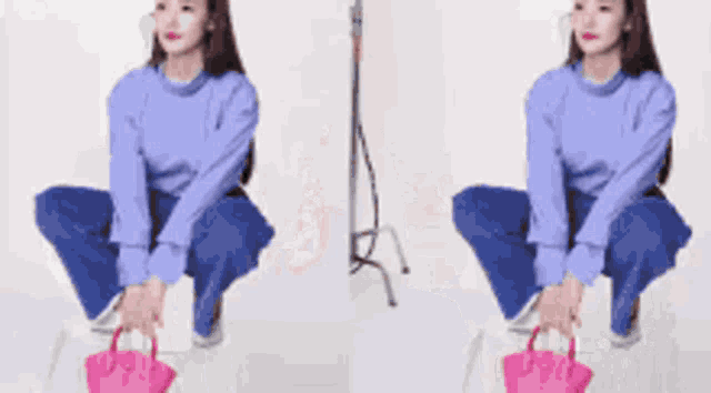 a woman in a blue sweater is smiling with her arms in the air