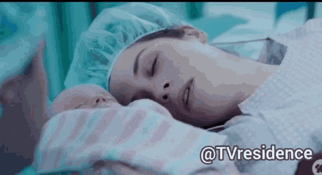a woman in a surgical cap holds a newborn baby