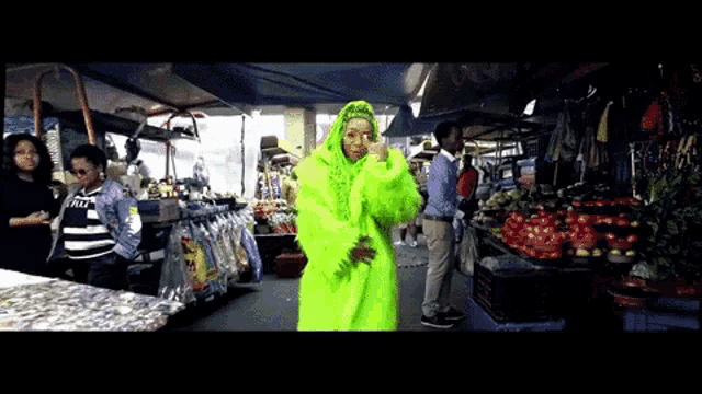 a woman in a neon green outfit is standing in front of a market