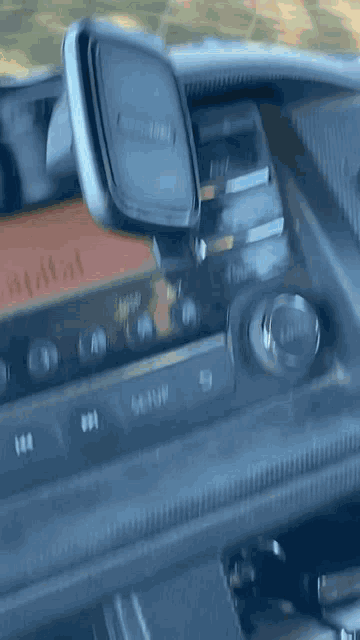 a close up of the dashboard of a car with a phone holder and a gps tracker