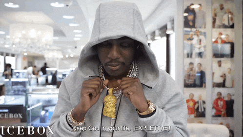 a man wearing a hoodie and a necklace says keep god in your life explicitly