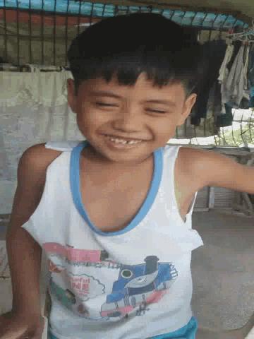 a young boy wearing a shirt that says thomas the train on it