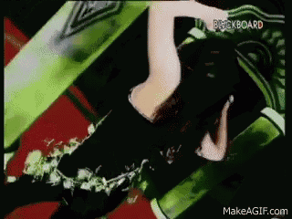 a woman is laying on a green couch in a video .