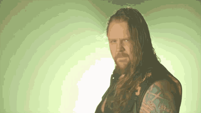 a man with long hair has a tattoo on his arm