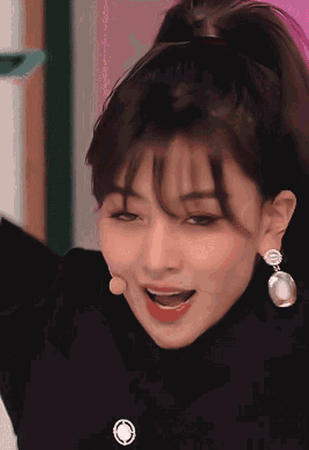 a close up of a woman wearing earrings and smiling