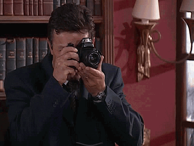a man in a suit is taking a picture with a camera