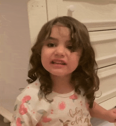 a little girl is wearing a shirt that says baby angel on it