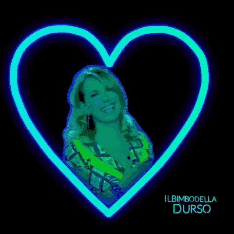 a woman is smiling in a heart shaped neon sign