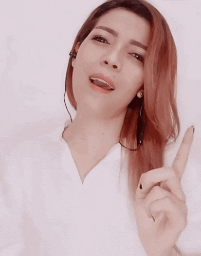 a woman with red hair is wearing a white shirt and headphones