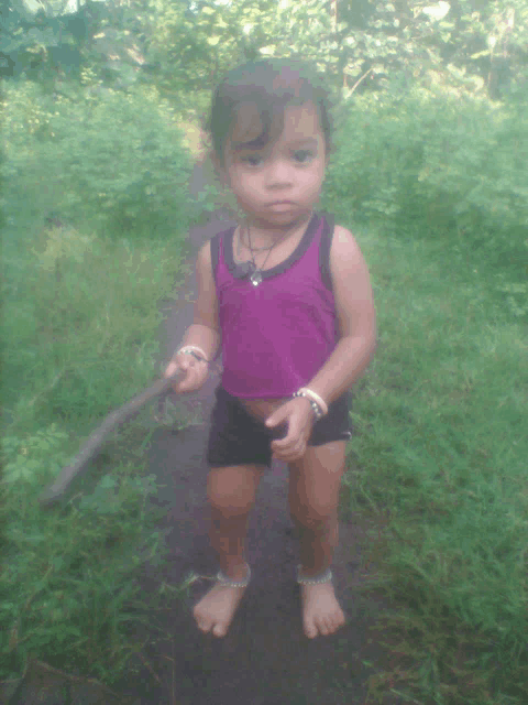 a little girl wearing a purple tank top and black shorts