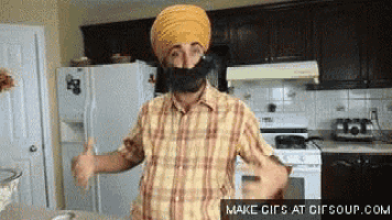 a man wearing a turban and beard giving a thumbs up