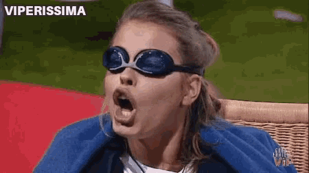 a woman wearing swimming goggles is sitting in a chair .