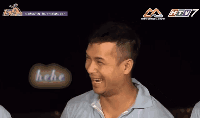 a man is smiling in front of a screen that says htv7 madison media group
