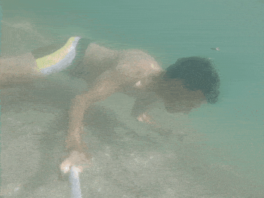 a man in a yellow and black swim suit is swimming underwater