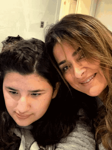 a woman and a girl are smiling for the camera