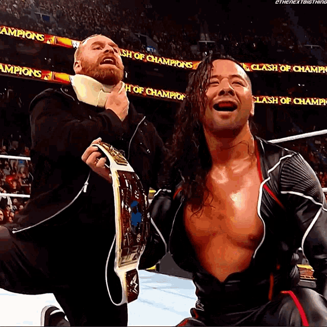 two wrestlers are posing for a picture in front of a clash of champions sign