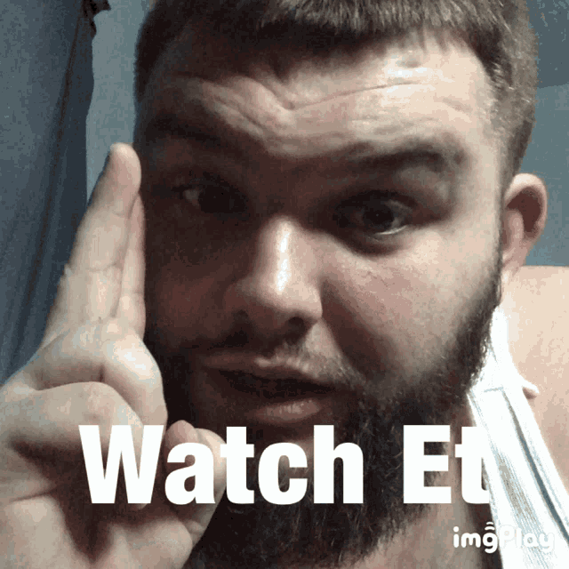 a man with a beard is pointing his finger at the words watch et