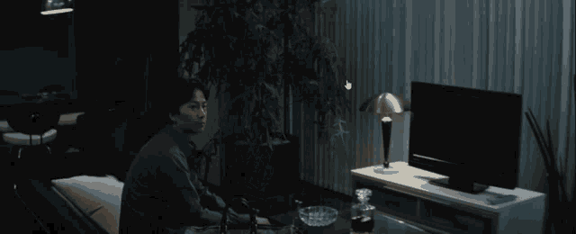 a man sits on a couch in front of a tv