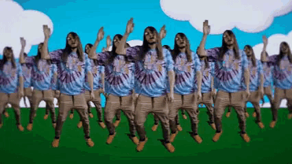 a group of people wearing tie dye shirts are dancing