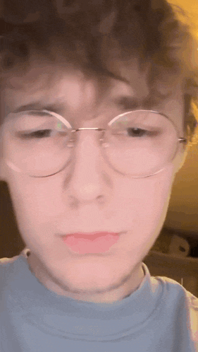 a young man wearing glasses and a blue shirt