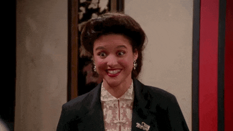 a woman in a black jacket and white blouse is smiling .
