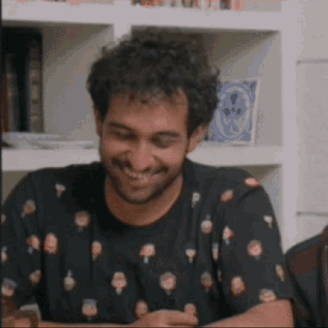 a man with curly hair and a beard is smiling