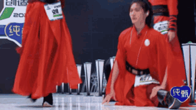 a man in a red dress is kneeling down on the floor