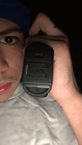 a man is holding a black glock gun in his right hand