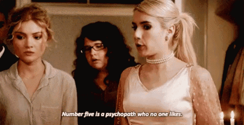 three women are standing next to each other in a room and one of them is talking about a psychopath who no one likes .
