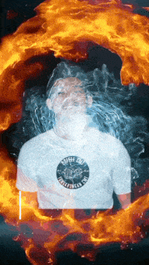 a man wearing a white shirt that says afff on it is surrounded by fire