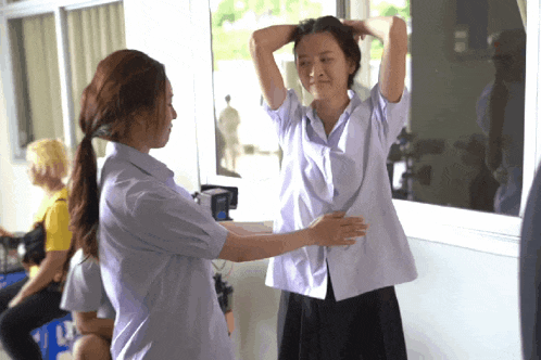 a girl in a white shirt is being hugged by another girl