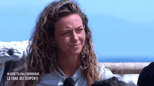 a woman with curly hair is crying with the words in diretta dall ' honduras la tana dei serpenti on the bottom