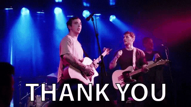 two men are playing guitars and singing on a stage with the words `` thank you '' written below them .