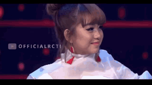 a girl with a bun on her head is smiling with the words officialrcti behind her