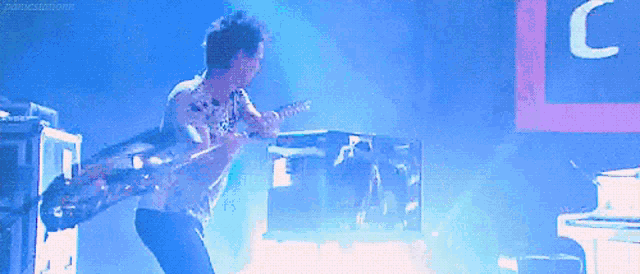 a man is playing a guitar on stage in front of a sign that says c
