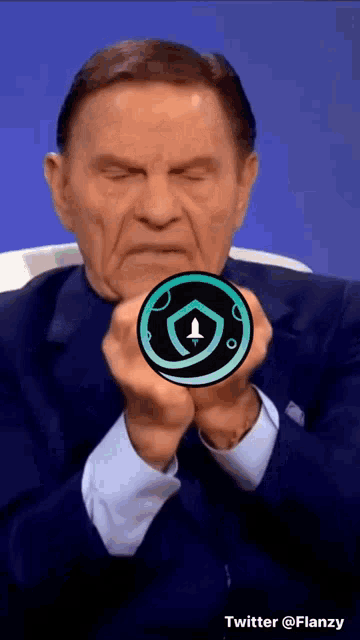 a man in a suit is holding a coin with a rocket on it in his hands