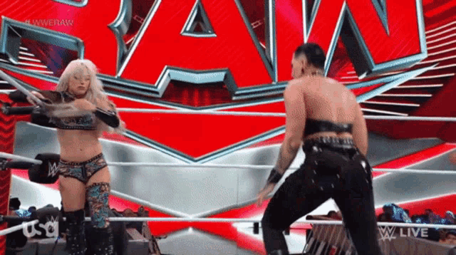 a female wrestler and a male wrestler are dancing in front of a wwe logo